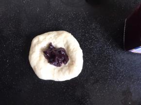 再擀成面饼，放入蓝莓果酱，像包子一样收口