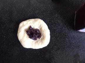 再擀成面饼，放入蓝莓果酱，像包子一样收口
