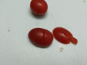 圣女果竖着切下五分之一，再切口朝下，在三分之一处斜切不要到底，在五分之一上面再切V子型，