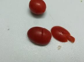 圣女果竖着切下五分之一，再切口朝下，在三分之一处斜切不要到底，在五分之一上面再切V子型，