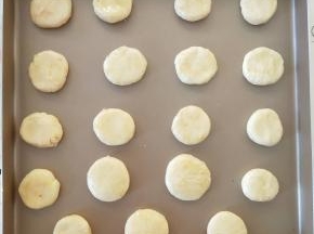 7、分割成每个12克的小面团。放在学厨9055金盘中，撮圆压扁，表面刷蛋黄液
可