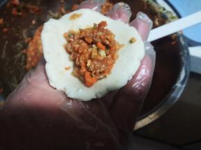 将面皮按扁，包入馅料