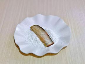 玉米淀粉放入盘中，取一段腌制好的带鱼，均匀裹上淀粉，依次做完。