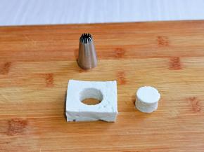 待豆腐不烫手时取一片豆腐，用一个小圆形状的裱花嘴在豆腐中间压出一个圆，依次做完。