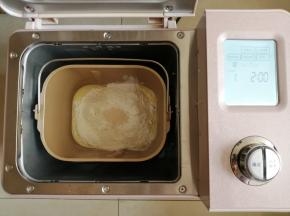 往面包桶里依次倒入水、蛋液、糖、盐、奶粉和面粉，在面粉顶端倒入酵母。把面包桶放入到东菱JD08面包机里，选择面包机的和面程序10分钟