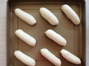 从上往下卷起，放在不粘烤盘上。放入烤箱，用烤箱的发酵档35度发酵50分钟左右，发酵有两倍大