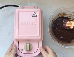 将核桃仁掰成小块放入到巧克力糊中，轻食机预热后，将巧克力糊倒入到松饼烤盘中（也可以见巧克力糊放入到垫有油纸的模具中，放入到烤箱烘烤，180度20分钟左右，具体时间要根据面糊的厚度酌情增减，注意观察表面微微开裂即可）