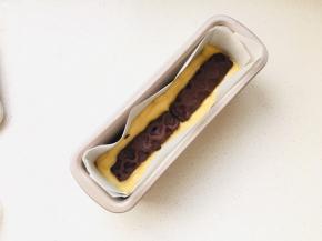 将面糊挤入到模具中，然后将夹心摆放在中间位置，再将剩下的面糊挤入到模具中