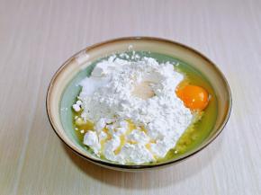 首先将面粉放入大口器具中，加入盐，玉米油，鸡蛋，面粉顶部挖个坑，加入酵母粉。