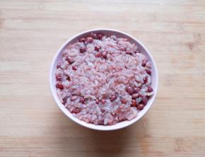 将蒸好的红豆糯米饭装在碗里，用勺子压实。