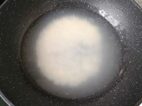 将酒酿倒入锅里，加入适量的水烧开。