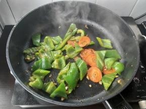 再加入少许盐，大火翻炒，把青椒炒至7-8分熟。