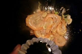 放入大虾炒红后倒入生抽。