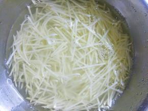 把土豆去皮洗净擦丝后过清水两次，加入热开水烫一下后过凉水待用。