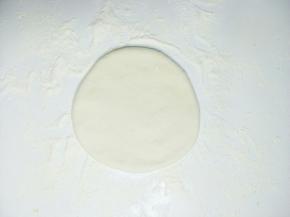 取一个小面团擀成直径约12厘米左右的薄饼。