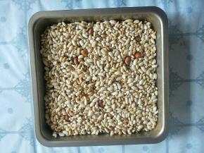 把米花盛入提前刷油的方形烤盘中压实。