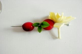 把茉莉花和蔓越莓、绿叶用水果针串起。