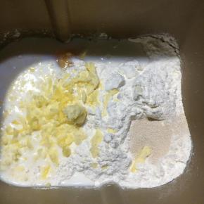 把制作面包所需要的材料除黄油外，其它的一同放入面包桶内启动和面程序10分钟，