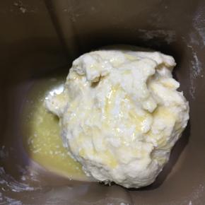 10分钟后加入隔水融化后的黄油，再次启动15分钟，揉至面团有一定的延展性即可。