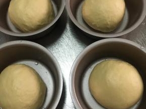 取出面团排出气体，称重平均分割成四等份或更多，放入模具中进行二次发酵至1.5倍大即可，