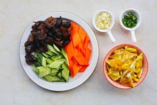 黑木耳提前泡发，胡萝卜、黄瓜洗净切菱形，鸡蛋煎熟切块备用。