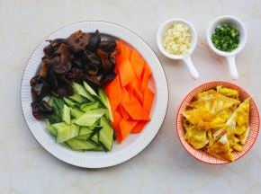 黑木耳提前泡发，胡萝卜、黄瓜洗净切菱形，鸡蛋煎熟切块备用。