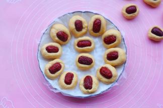 每个小剂子搓长一点，弄一个小坑放上枣片，按紧。