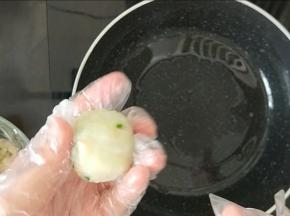 不粘锅里放少许食用油，然后戴上一次性的手套，把山药米饭捏成团，然后再稍微压扁。