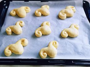 做好的小面包摆放在垫有油纸的烤盘中，并间隔距离，入烤箱进行发酵。(可以放一杯开水在烤箱里，可以增加发酵速度，同时保持面包胚的湿度)