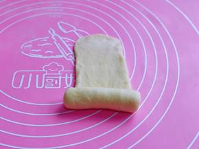 取一块面团，用擀面杖擀长舌状，由下往上卷起，收口处捏紧。