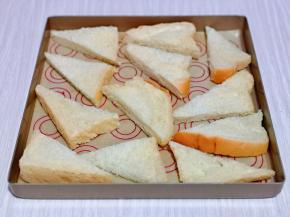 切好的吐司角摆放在垫有油纸的烤盘中。