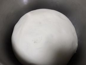 总水量的温水先取少量和酵母放在一起，不用搅拌让酵母自行溶解5分钟，温水最好是30度左右的，温度太高就会把酵母直接烫死了。面粉和其他原料倒进和面盆中，然后慢慢加入自醒好的酵母液，再把其余的温水也逐渐加入，合成一个光滑的面团，盖上保鲜膜夏季醒发15分钟，冬季醒发半个小时，这个时间是要根据实际温度而定的，我给出的都是参考时间，主要是看最后醒发的状态，一定记得要半发不是全发状态。