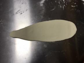 用擀面杖把水滴状上端擀长，