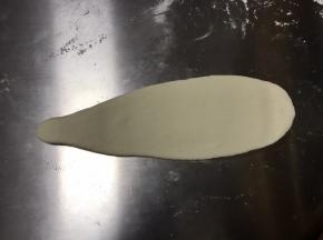 用擀面杖把水滴状上端擀长，