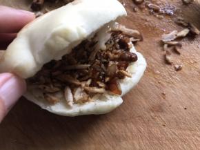 然后用薄刀顺着馍边切一刀，把剁好的肉用刀直接塞入切开口的馍里边，浇少许卤汁，