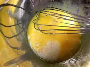 蛋黄中加入牛奶，用手动打蛋器搅打均匀