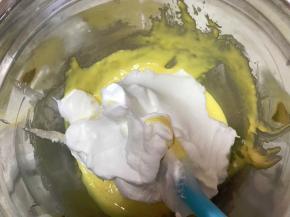 将蛋白霜分3次加入蛋黄糊中，用刮刀Ｊ字翻拌