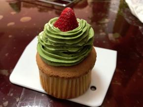 纸杯蛋糕晾凉后，把草莓放在顶部中间，把奶油围着草莓旋转向上挤出圣诞树造型