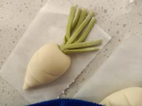 萝卜头顶用工具戳一个洞，将做好的萝卜叶子塞进去