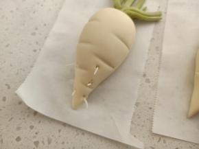 用第2步留出来的2克白面团搓成细长条，用牙签截取一小截，直接塞进萝卜里，这样有胡须的白萝卜更加逼真