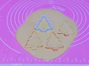 面团从冰箱取出，用擀面杖将面团擀薄，可以在面团上盖一张油纸后再擀，这样擀出来比较光滑，再用模具压出圣诞树的形状就可以啦，将边角的面团反复压完。