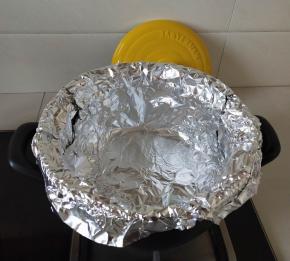 裁取几张比锅体稍大的锡纸，放入砂锅内，按服帖，让锡纸紧挨锅壁。