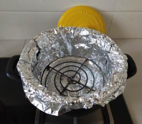 放入烤架，烤架上再放一张锡纸，防止红薯汁液弄脏烤架和砂锅。