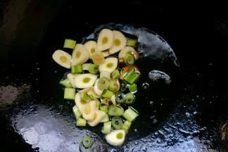 锅中倒入植物油开小火，油温七成热放入葱蒜炒香。