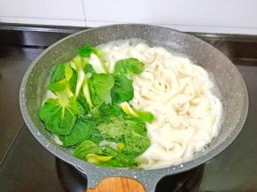 看面条快熟时加入青菜烫熟。
