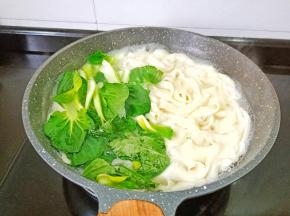 看面条快熟时加入青菜烫熟。
