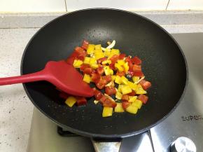 下入红椒丁和黄椒丁翻炒；