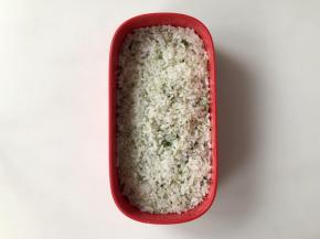 把拌好的米饭盛到便当盒中，压平。