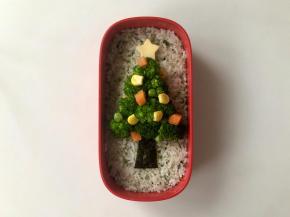 在芝士片上用模具压出一个五角星，放在圣诞树顶部，圣诞树上用什锦果蔬粒装饰。