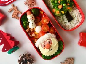 然后把圣诞老人饭团、鹌鹑蛋小雪人放在配菜上，再用切开的圣女果和西兰花装饰一下。完成！